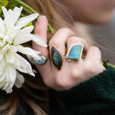 rings on a hand holding a flower, from micky roof collection -opal