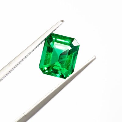 tweezer holding green gem